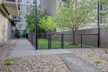 a fenced in tennis court with trees and a chain link fence